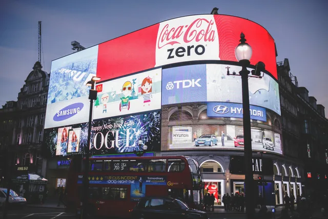 Night view of Piccadilly Circus in London with bright billboards and a red double-decker bus. How to vet ad creative compliance software for UK campaigns